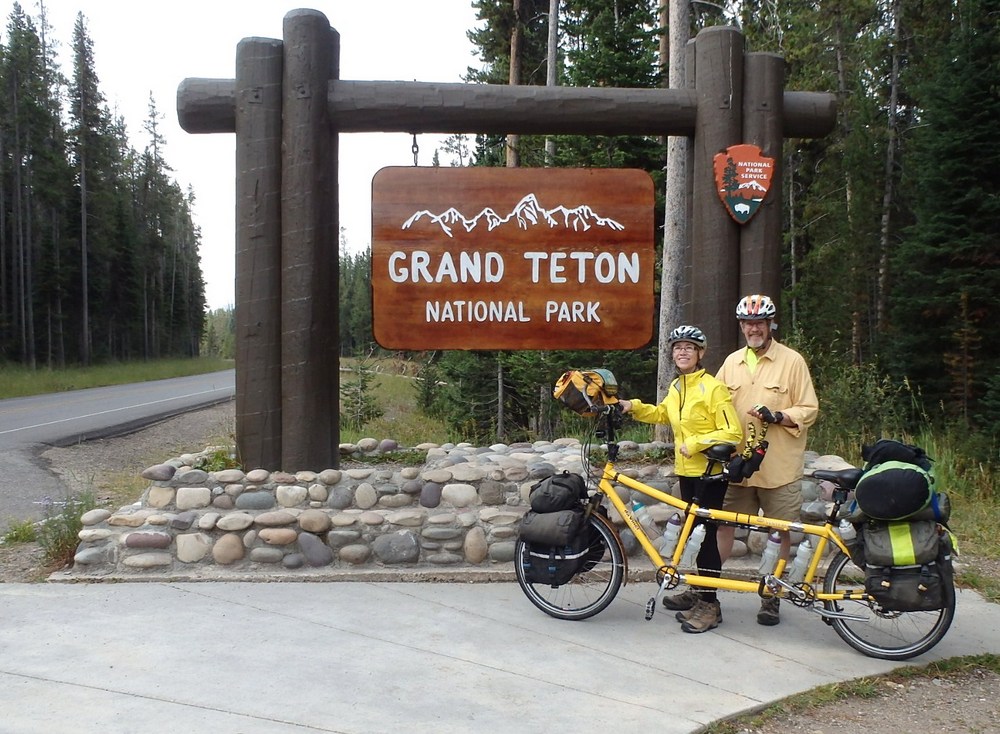 GDMBR: Dennis and Terry Struck with the Bee (a da Vince Tandem) on the Great Divide Mountain Bike Route (GDMBR) at the Grand Teton National Park's south entrance welcome station.